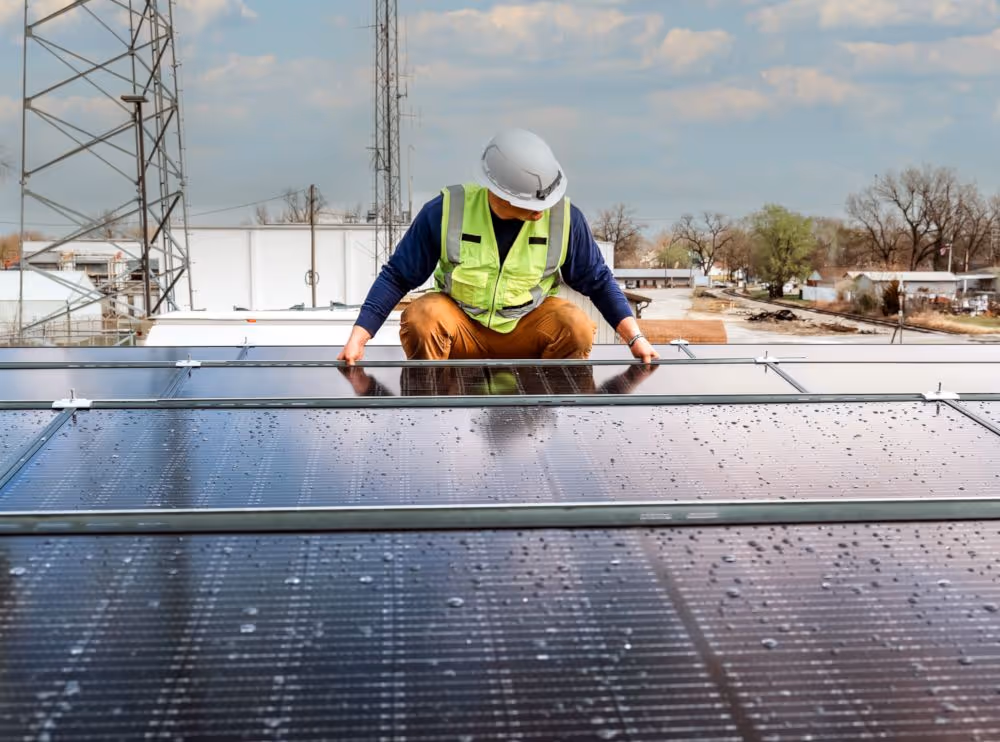 Solar technician installing commercial rooftop solar panels – reduce operational costs and increase sustainability with business solar solutions in the U.S.
